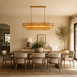 Amber fluted-glass linear chandelier above a dining table.