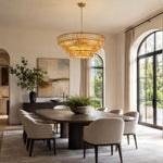 Amber round chandelier above a table by arched windows.