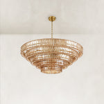 Angled view of an amber tiered glass chandelier.