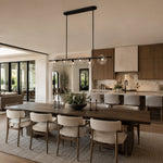 Black bubble glass linear chandelier above a dining table in an interior setting
