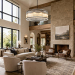 Black glass rod chandelier in a high-ceiling living room beside a stone fireplace