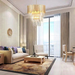 Cascading crystal chandelier in a living room beside a tall window.