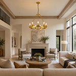Candle ring chandelier over a round coffee table in a beam-ceiling living room.