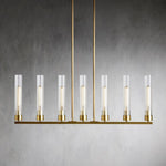 Seven clear glass cylinders on a brass-tone linear chandelier.