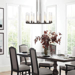 Cylinder ring chandelier above a set dining table in a bright room.