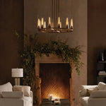Illuminated cylinder ring chandelier in front of a fireplace.