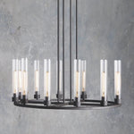 Wide black cylinder ring chandelier against a gray wall.