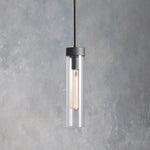 Illuminated single glass cylinder pendant with a black cap and rod.