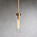 Illuminated single glass cylinder pendant with a brass-tone cap and rod.
