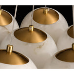 Close-up of alabaster globe shades with brass-colored caps and visible stone veining