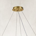Brass-tone round chandelier canopy and suspension-wire detail.
