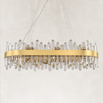Unlit oval chandelier with a gold-tone band and clear faceted rods.