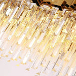 Close-up of illuminated crystal rods along the oval chandelier's lower edge.