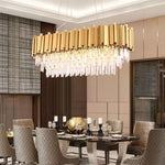 Oval crystal crown chandelier above a dining table in a paneled room.