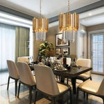 A pair of crystal crown pendants hanging above a dining table.