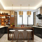 Three crystal crown pendants above a kitchen island with stools.