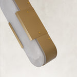 Close view of the brass bracket and alabaster panel on a pill wall sconce