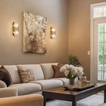 Two brass finish oval alabaster wall sconces above a living room sofa
