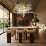 Brass-finish crystal branch cascade chandelier above a dining table