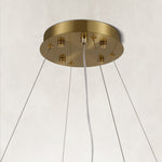 Gold-tone canopy and suspension cables of a layered ring chandelier.