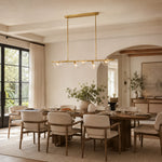 Gold-tone bubble glass chandelier above a dining table near a window