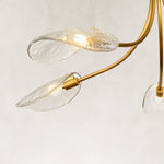 Gold-tone chandelier illuminated glass leaves close view