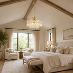 Gold-tone crystal chandelier shown in a bedroom with pitched ceiling