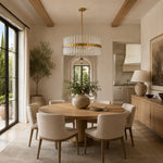 Glass drum chandelier above a round dining table beside tall windows.