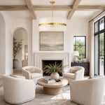 Glass drum chandelier above white armchairs in front of a fireplace.