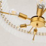 Glass drum chandelier, bulbs and gold-tone spokes inside the frame.