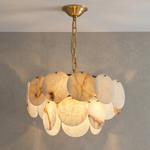 Illuminated two-tier alabaster disc chandelier hanging against a gray wall
