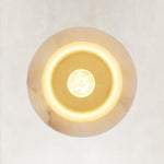 Illuminated underside of a cylindrical stone pendant.