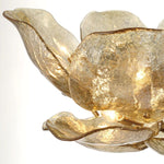 Close-up of overlapping gold glass petals and visible lights.