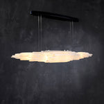 Angled illuminated selenite linear pendant with a black canopy.