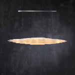 Front of a layered selenite linear pendant with a silver-tone canopy.