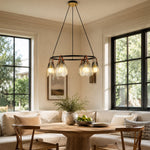 Ring chandelier with ribbed glass shades, window-corner dining setting.