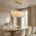 Matching complete two-tier fixture above oval/round dining table near window