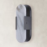 Unlit oval alabaster wall sconce with black hardware.