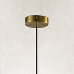 Brass-colored pendant canopy with a black suspension cable.