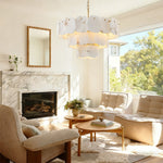 Brass-finish three-tier scalloped alabaster chandelier above a living room seating area