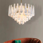 Alabaster panel chandelier hanging above a rust-colored sofa.