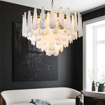 Illuminated alabaster chandelier in a living room with a white sofa.