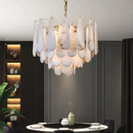 Tiered alabaster chandelier above a round dining table.