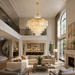 Gold-tone tiered crystal drum chandelier in a double-height living room with a gallery landing.