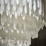 Close-up of pointed selenite pieces arranged in overlapping rows.