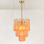Illuminated chandelier with textured amber drops and a gold-tone ceiling canopy.