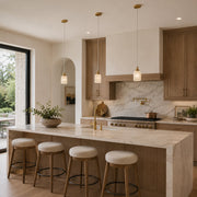 Three illuminated cylindrical pendant lights above a stone kitchen island
