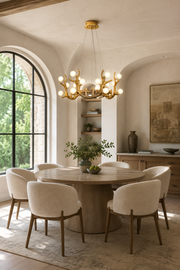 Gold branch chandelier with white globes above a round dining table