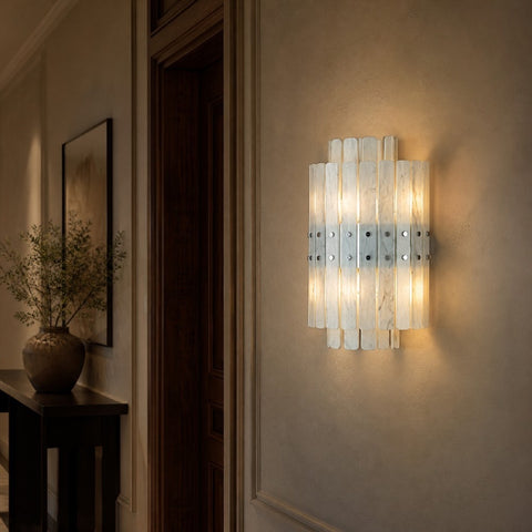 Wall sconces creating layered light in a refined corridor