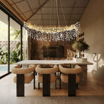 Brass-finish crystal branch linear chandelier in a furnished room